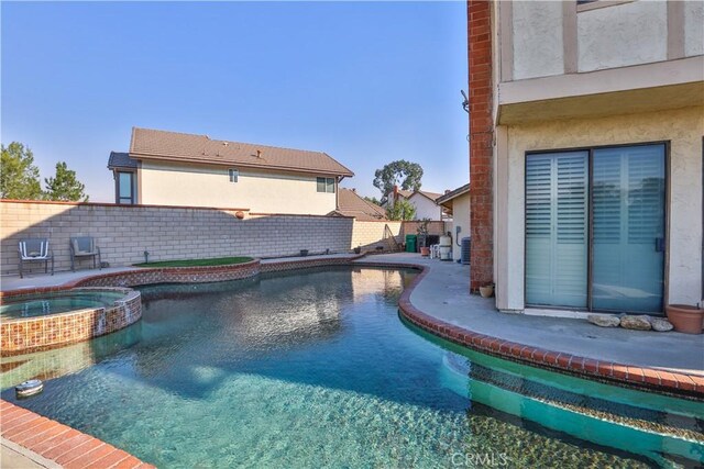 view of pool with an in ground hot tub