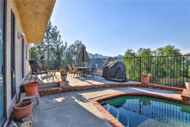 view of pool featuring a grill and a patio area