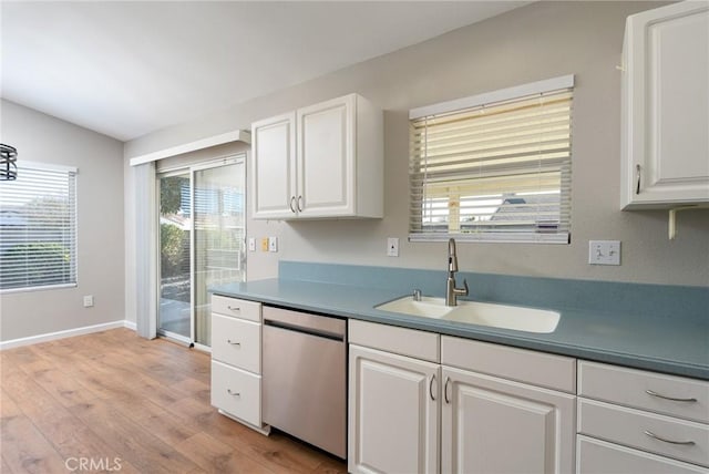 kitchen with dishwasher, sink, vaulted ceiling, light wood-type flooring, and white cabinetry