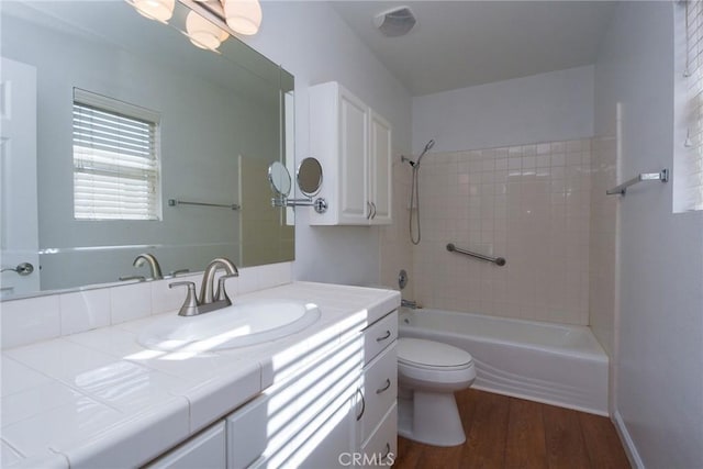 full bathroom with wood-type flooring, vanity, toilet, and tiled shower / bath