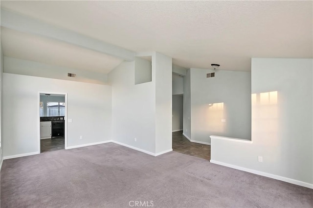 empty room with carpet flooring and vaulted ceiling with beams