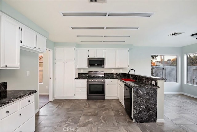 kitchen with sink, white cabinets, dark stone countertops, and stainless steel appliances