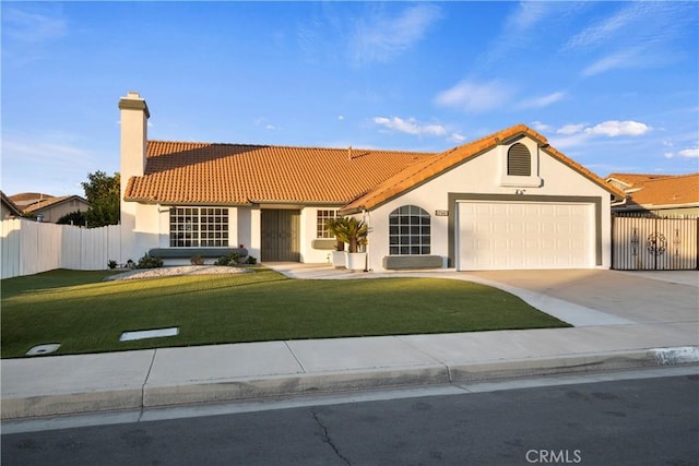 mediterranean / spanish home featuring a front yard and a garage