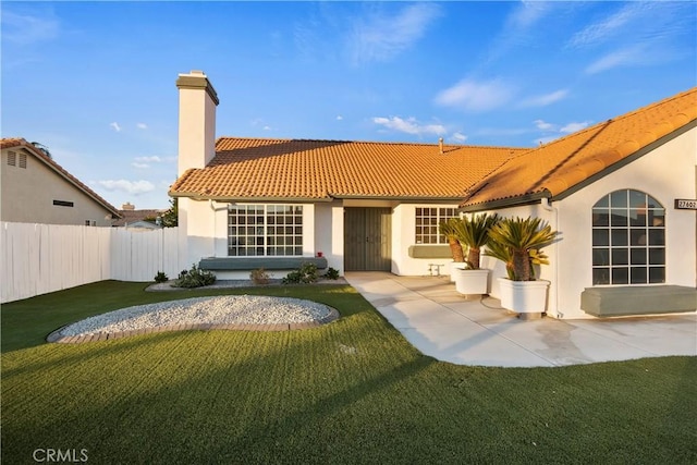 back of house featuring a lawn and a patio area