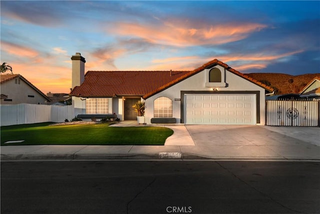 mediterranean / spanish house featuring a yard and a garage