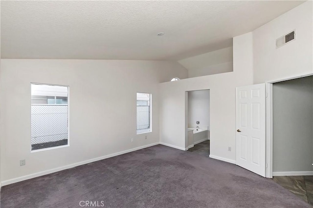 carpeted empty room featuring vaulted ceiling