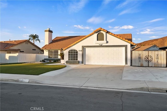 mediterranean / spanish house featuring a garage and a front yard