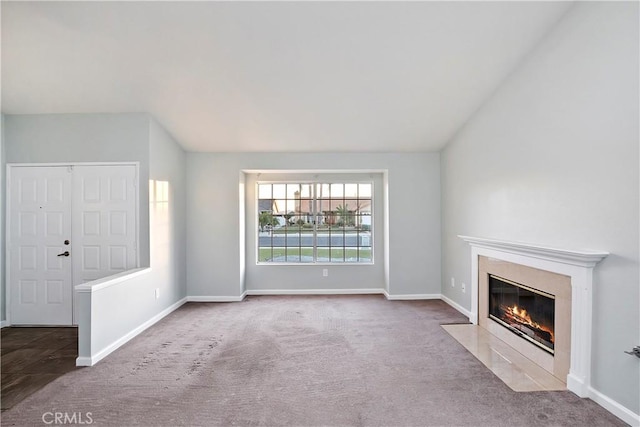 unfurnished living room with carpet floors and vaulted ceiling