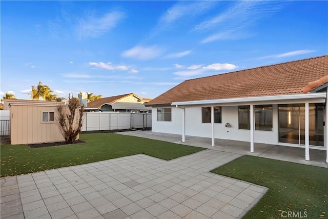 rear view of property featuring a lawn and a patio area