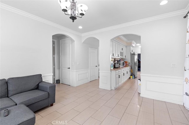 living room featuring an inviting chandelier, ornamental molding, and light tile patterned floors