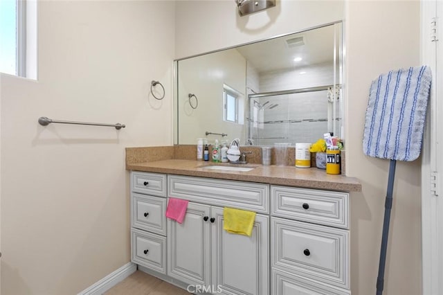 bathroom featuring vanity and a shower with shower door