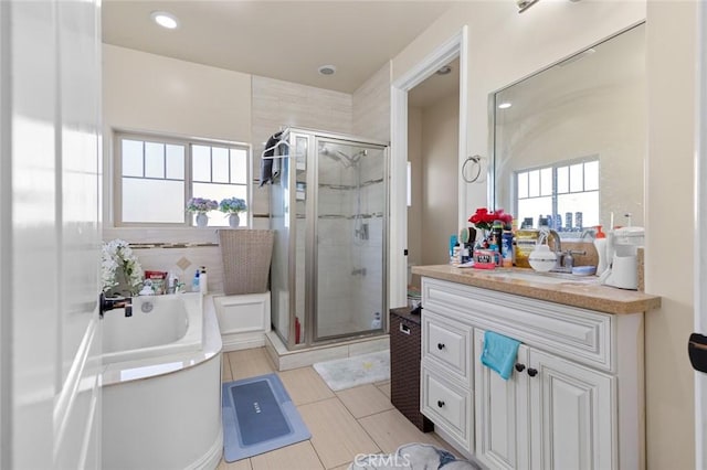 bathroom with tile patterned flooring, vanity, and shower with separate bathtub