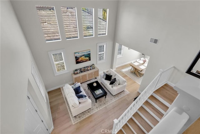 living room featuring light hardwood / wood-style floors and a high ceiling