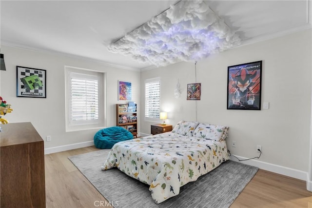 bedroom with ornamental molding and light wood-type flooring