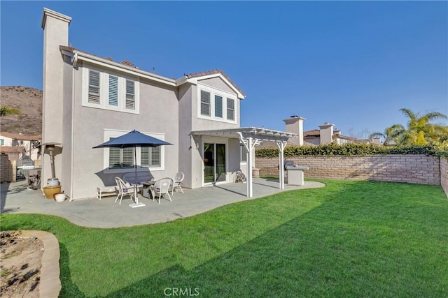 back of house with a pergola, a yard, and a patio