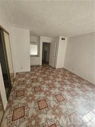 unfurnished room featuring a textured ceiling