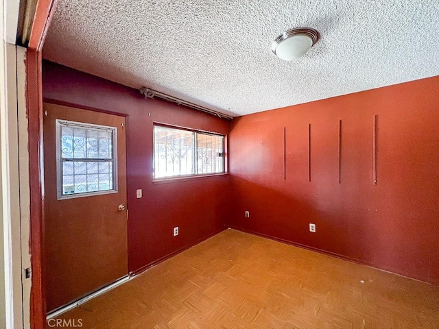 interior space featuring a textured ceiling and light parquet flooring