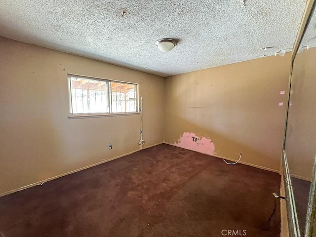 carpeted spare room featuring a textured ceiling