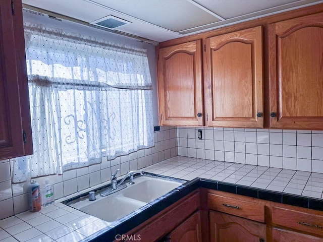 kitchen with sink, tile countertops, and tasteful backsplash