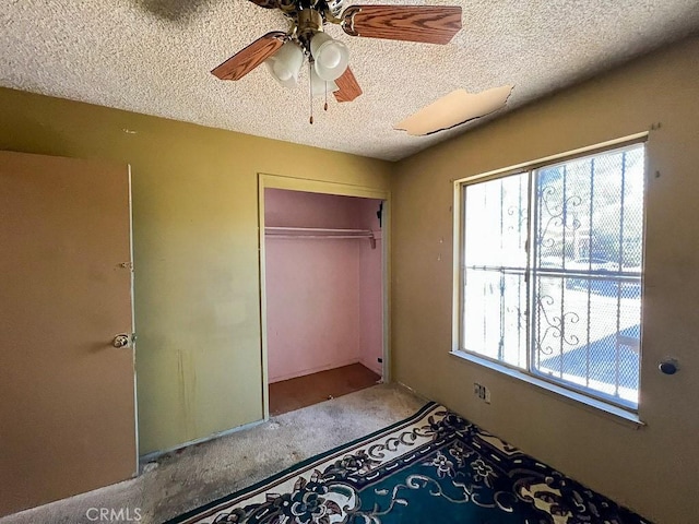 unfurnished bedroom with a textured ceiling, a closet, and ceiling fan