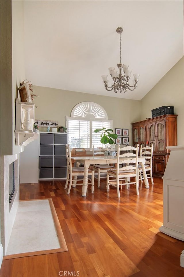 unfurnished dining area with lofted ceiling, a notable chandelier, and dark hardwood / wood-style flooring