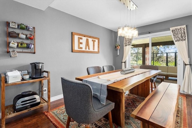 dining area with a chandelier and dark wood-type flooring