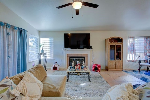 living room with ceiling fan, light tile patterned floors, and a tiled fireplace