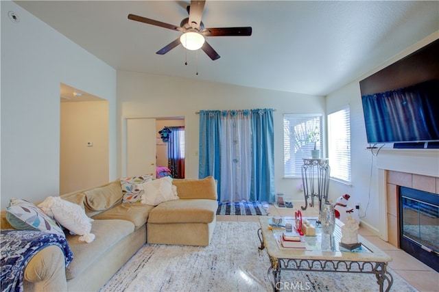 tiled living room with ceiling fan, a fireplace, and lofted ceiling