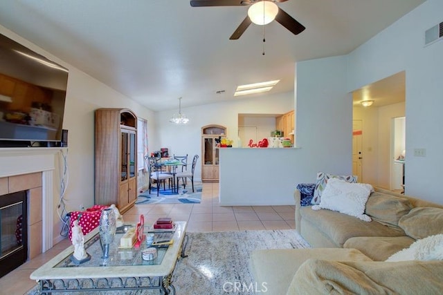 tiled living room with ceiling fan, a fireplace, and lofted ceiling