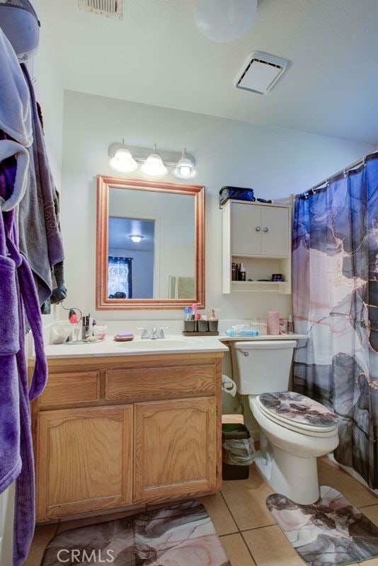 bathroom featuring tile patterned flooring, vanity, and toilet