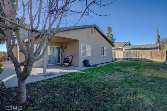 rear view of property featuring a yard and a patio