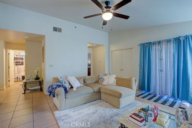 living room with ceiling fan, light tile patterned flooring, and lofted ceiling