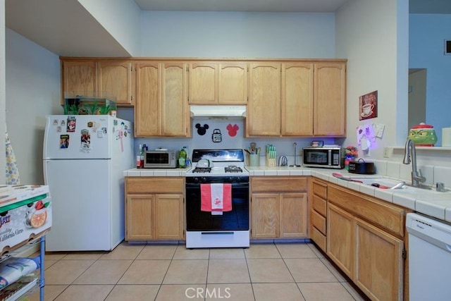 kitchen featuring light tile patterned flooring, white appliances, tile counters, and sink