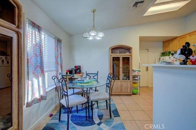 tiled dining room with an inviting chandelier and lofted ceiling