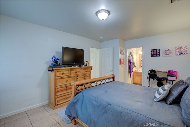 bedroom featuring light tile patterned floors and ensuite bath