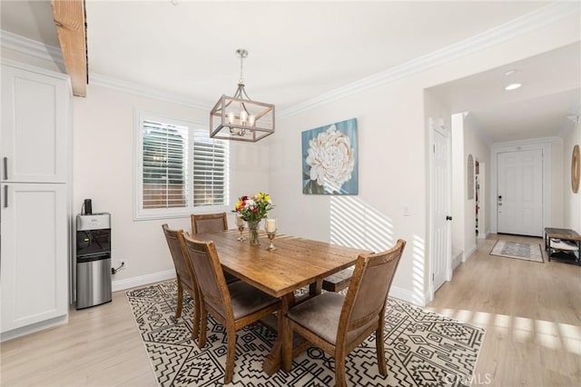 dining space with light hardwood / wood-style floors, ornamental molding, and a notable chandelier