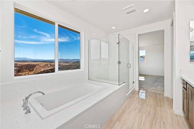 bathroom with vanity, a mountain view, and independent shower and bath