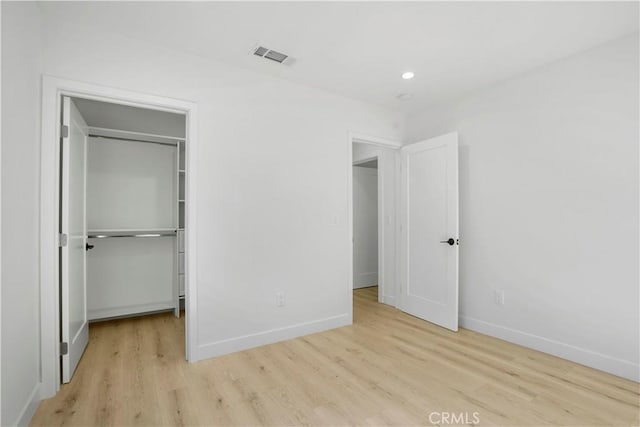 unfurnished bedroom with a closet and light hardwood / wood-style flooring