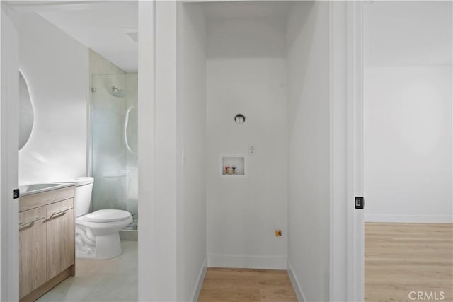 bathroom featuring a shower, hardwood / wood-style floors, vanity, and toilet