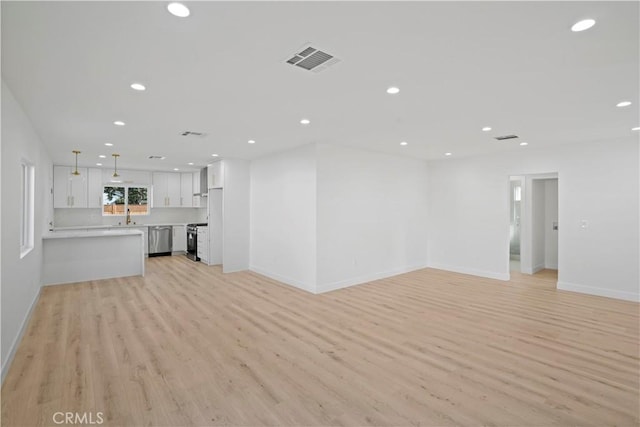 unfurnished living room with light wood-type flooring and sink