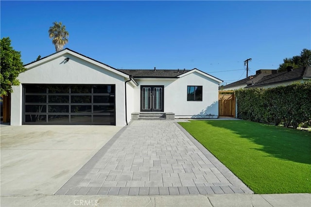 single story home with a garage and a front lawn