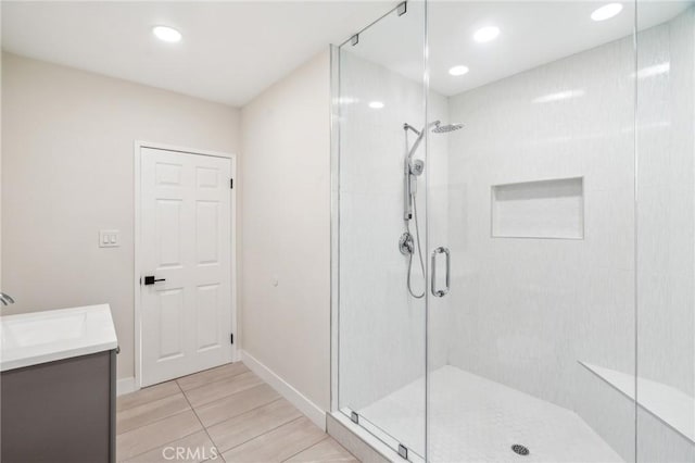 bathroom featuring vanity and a shower with door