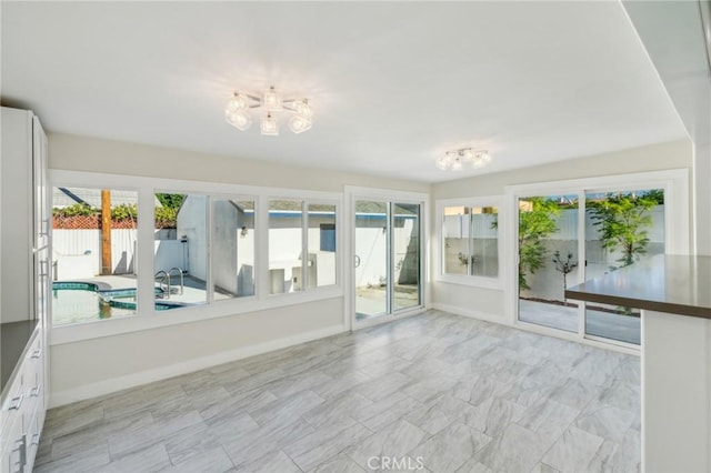 unfurnished sunroom featuring a wealth of natural light