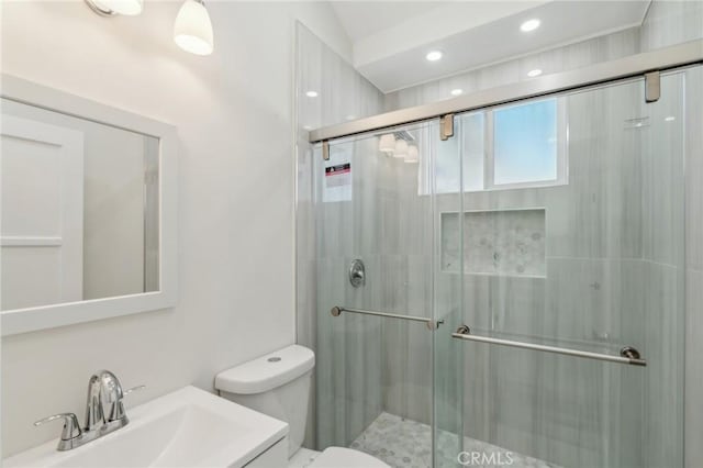 bathroom with vanity, toilet, and a shower with shower door