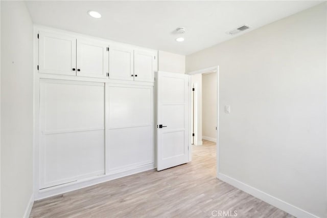 unfurnished bedroom with light hardwood / wood-style floors and a closet