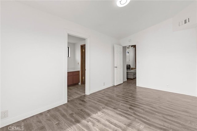 unfurnished room featuring light hardwood / wood-style flooring and lofted ceiling