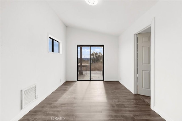 empty room featuring dark hardwood / wood-style flooring and vaulted ceiling