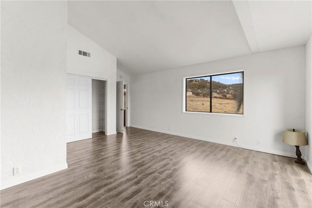 unfurnished room with wood-type flooring and vaulted ceiling