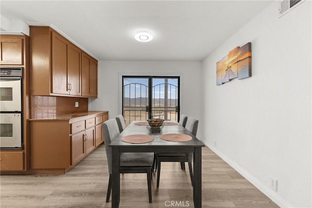 dining space with light hardwood / wood-style floors