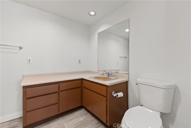 bathroom with hardwood / wood-style flooring, vanity, and toilet